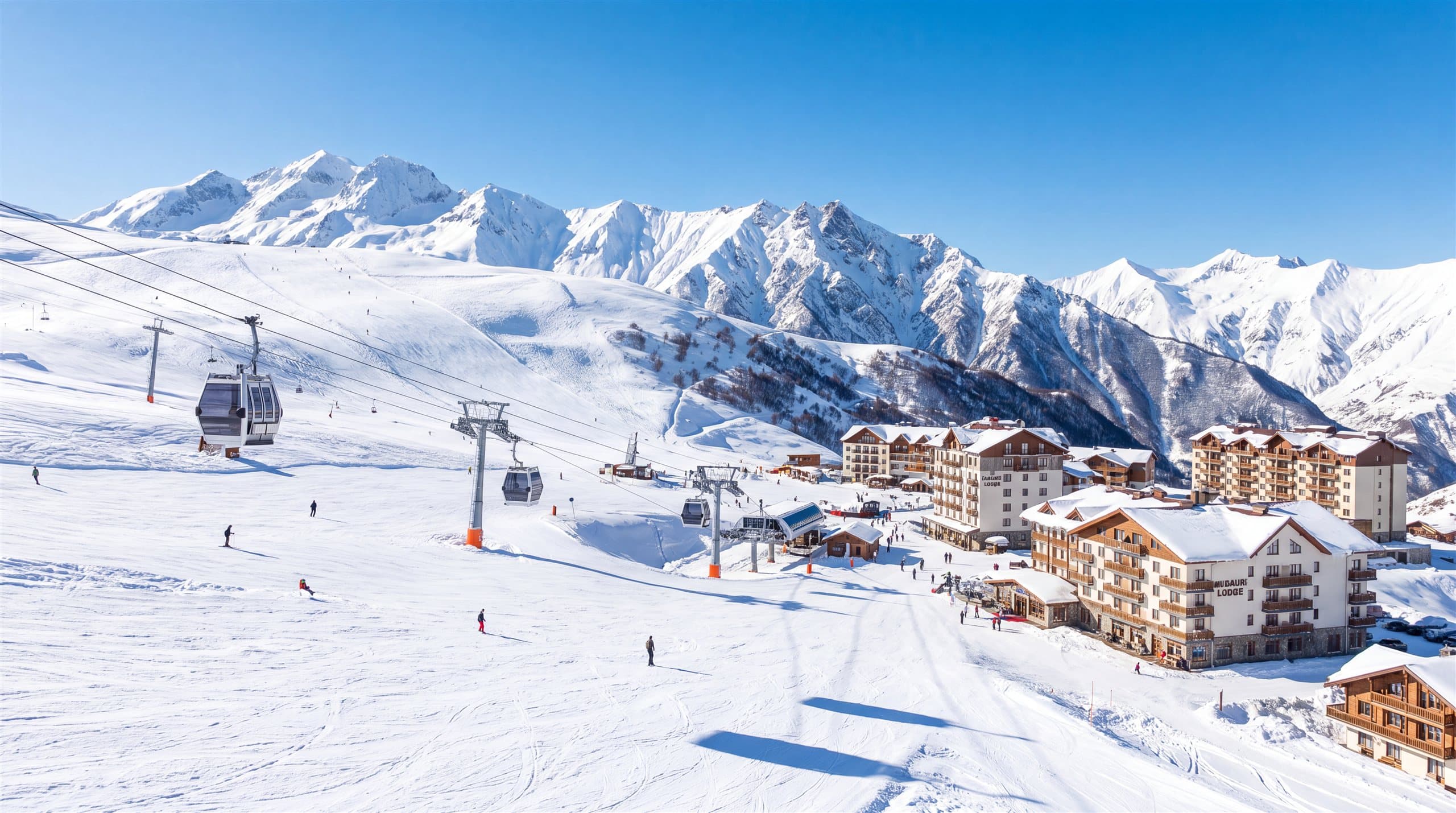 Skiers and gondolas on the sunny pistes of a high-alpine resort